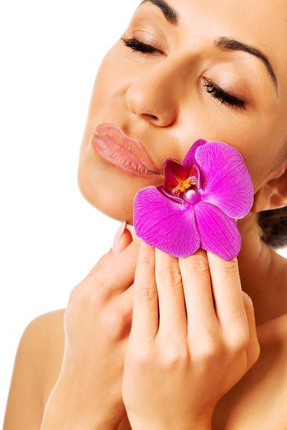 Woman with purple orchid and closed eyes - Fotoğraf, Görsel