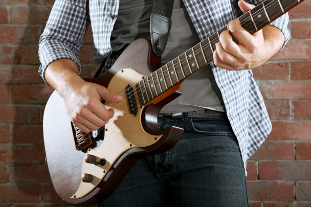 Young man playing guitar  - Foto, Imagen