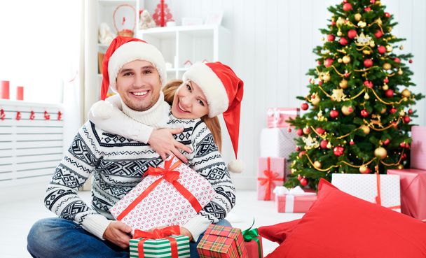 happy  family couple with a gift on Christmas at home - Zdjęcie, obraz