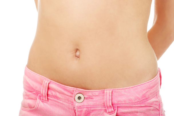 Slim woman wearing jeans showing belly. - Valokuva, kuva