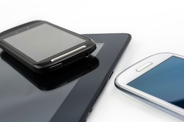 Zwarte Smartphone op zwarte Tablet met witte Mobile naast - Foto, afbeelding