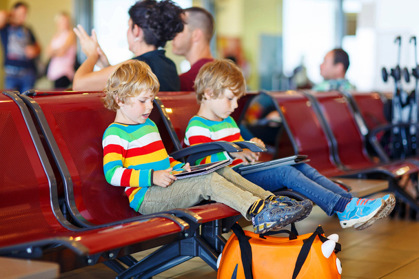 Two tired little sibling boys at the airport - 写真・画像