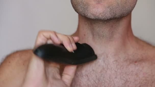 hombre sin camisa afeitándose con afeitadora eléctrica
 - Metraje, vídeo