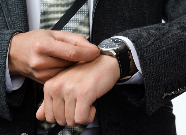 businessman adjusts the time on his wristwatch - Zdjęcie, obraz