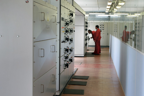 Electricians inspecting equipment in the switchboard room. - Foto, Imagen