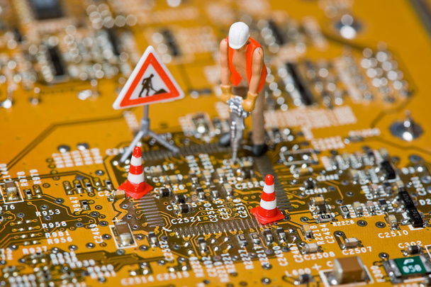 Miniature figures working on a circuit board. - Photo, Image