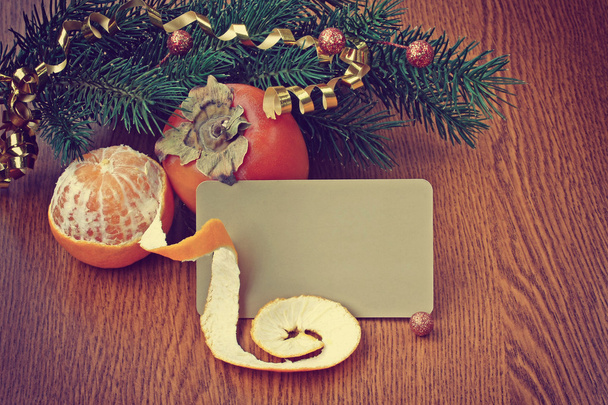 Christmas background with ripe persimmons and tangerine - Fotó, kép
