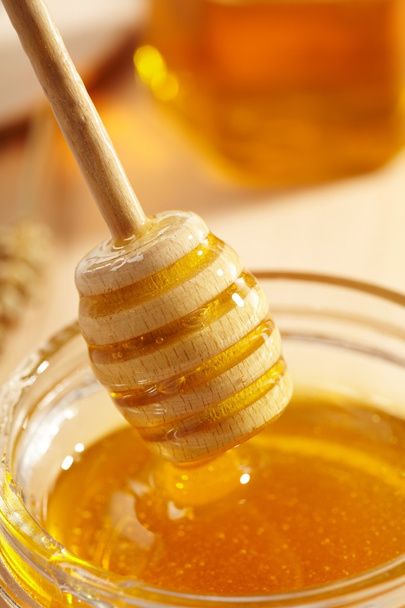 Honey with wood stick - Φωτογραφία, εικόνα
