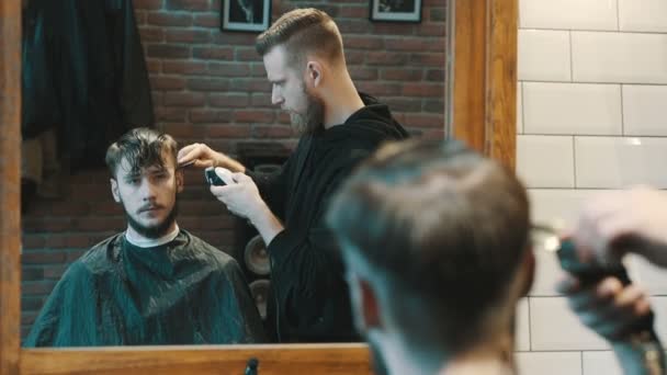Friseur schneidet dem Kunden mit Haarschneidemaschine die Haare - Filmmaterial, Video