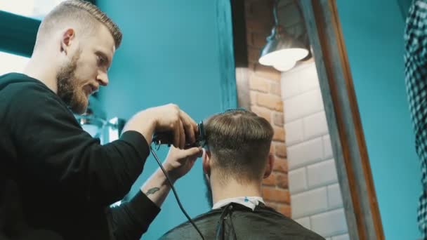 Peluquero corta el cabello del cliente con un cortador
 - Imágenes, Vídeo