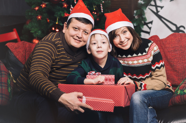 Dreiköpfige Weihnachtsfamilie mit roten Hüten - Foto, Bild