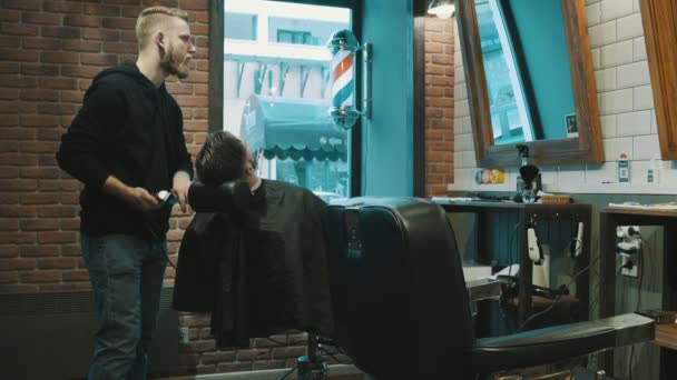 Peluquero afeitar la barba del cliente con trimmer
 - Metraje, vídeo