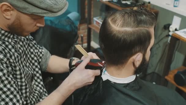 Barber cuts the hair of the client with trimmer - Imágenes, Vídeo
