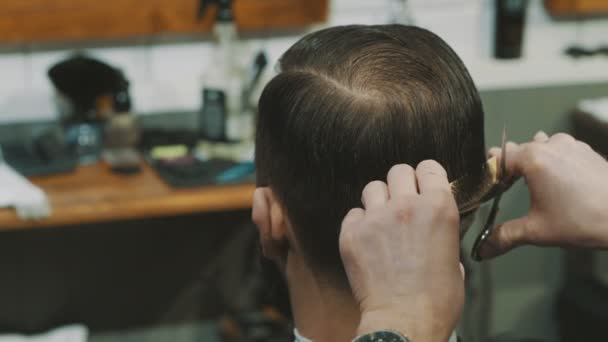 Barbeiro corta o cabelo do cliente com tesoura
 - Filmagem, Vídeo