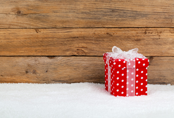 cadeau de Noël rouge avec neige, sur fond en bois
 - Photo, image