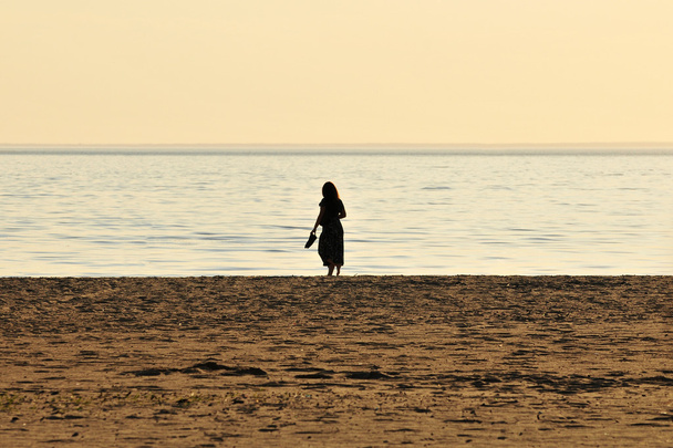 Kobieta spacerująca po plaży - Zdjęcie, obraz