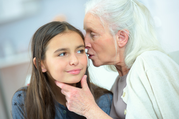 Little girl and grandma whispering secrets - Zdjęcie, obraz