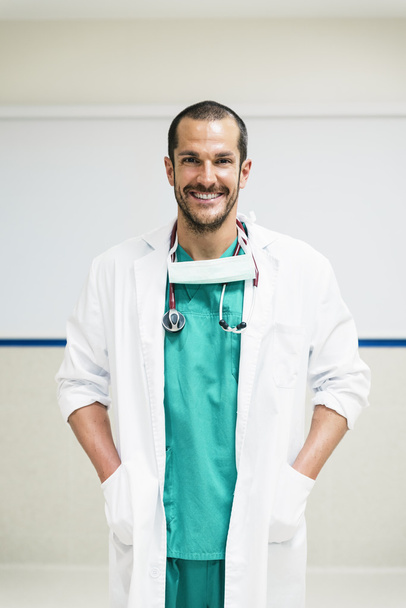Usměvavý pohledný doktor v nemocnici. Stojící. - Fotografie, Obrázek