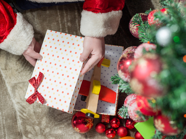 Santa Claus at Home putting gifts under Christmas Tree - Φωτογραφία, εικόνα