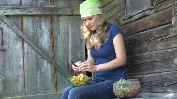 Mulher camponesa com lenço de cabeça limpos cogumelos chanterelle amarelos. 4K
 - Filmagem, Vídeo