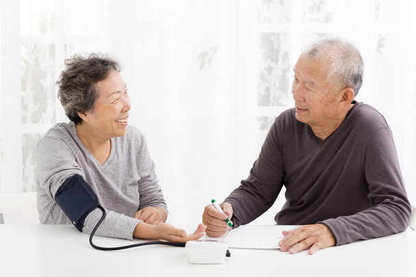 šťastný starší pár s krevní tlak v obývacím pokoji - Fotografie, Obrázek