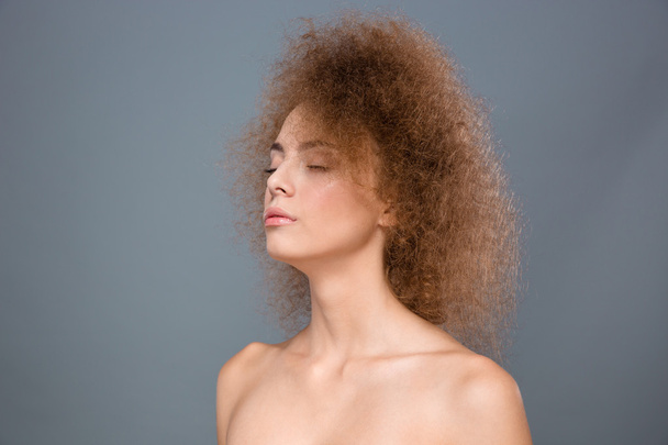 Closeup of young sensitive female with curly hair - 写真・画像