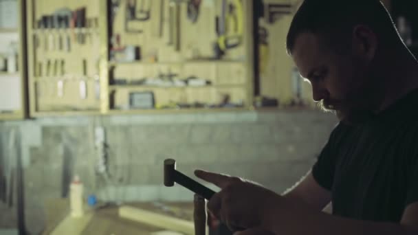 el carpintero corta el surco en la pieza de madera con el escoplo y el martillo
 - Imágenes, Vídeo