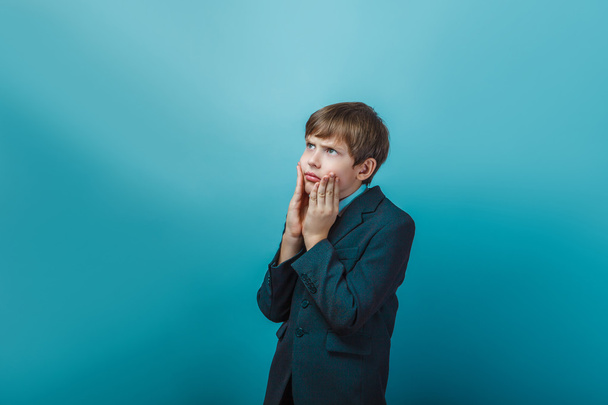 Teen boy of twelve European appearance in a business suit holdin - Foto, Imagem