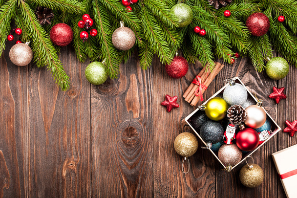 Fir tree decorated balls and box with decorations on dark wooden - Foto, afbeelding