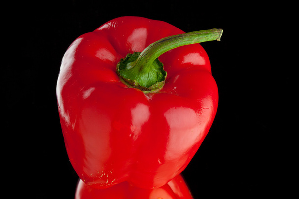 rode paprika's op een zwarte achtergrond - Foto, afbeelding