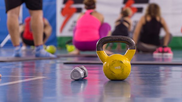Kettlebell amarillo del peso del fitness en el suelo
 - Foto, imagen