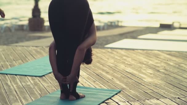 jonge vrouw beoefenen van yoga op het strand in de ochtend - Video
