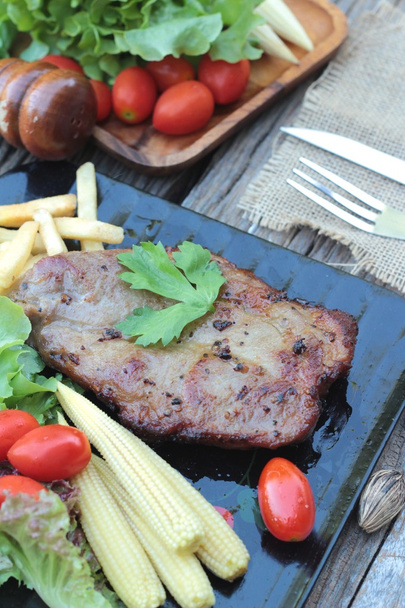 Свиной стейк вкусный с овощами и помидорами
. - Фото, изображение