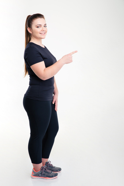 Жирная спортивная женщина, указывающая пальцем
  - Фото, изображение