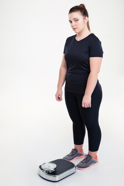 Fat woman standing with weighing machine - Φωτογραφία, εικόνα
