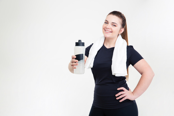 Smiling thick woman in sportswear holding shaker - 写真・画像