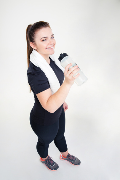 Happy fat woman in sportswear drinking water - Valokuva, kuva