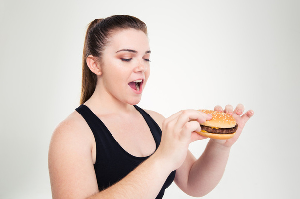 Portrait of a fat woman eating hamburger - Foto, imagen