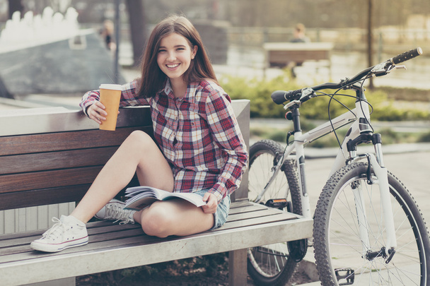 Young woman drinking coffee on a bicycle trip - Foto, afbeelding