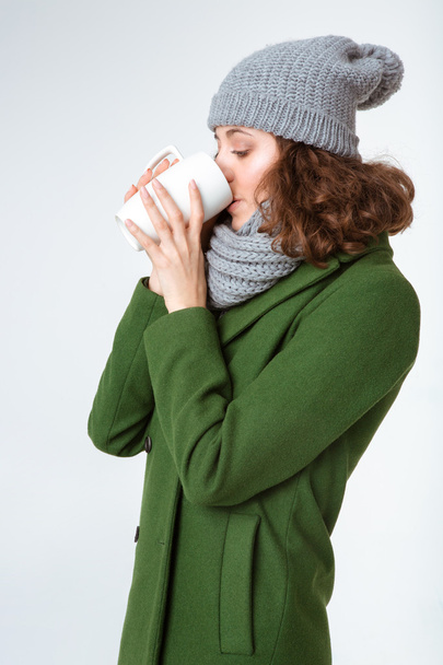 Woman in winter cloth drinking coffee  - Фото, зображення