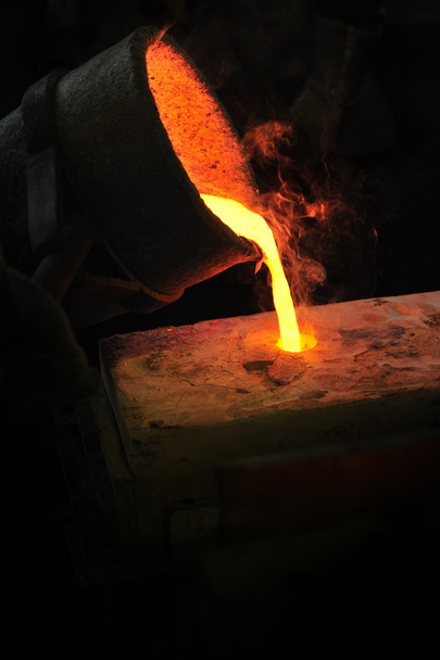 Литейное производство - расплавленный металл, выливающийся из ковша в плесень - потерянный воск литья
 - Фото, изображение