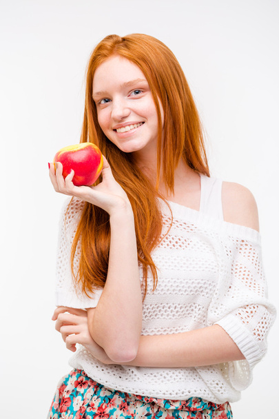 Beautiful happy girl with long red hair holding an apple - Фото, зображення
