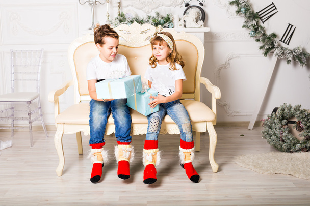 Niños felices con caja de regalo en la sala de estar en casa
 - Foto, imagen