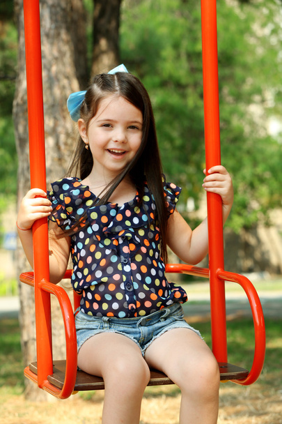 Happy little girl riding swings - Photo, Image