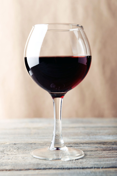 Glass of red wine on wooden table - Фото, изображение