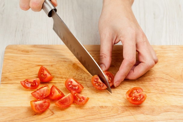 Couper les légumes avec un couteau de cuisine sur la planche
 - Photo, image