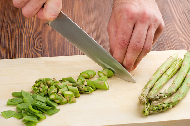 Cutting the vegetables with a kitchen knife on the board - Photo, Image