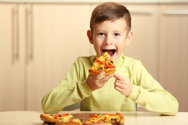Little boy eating pizza - 写真・画像