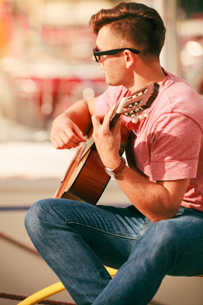 Trendy guy with guitar outdoor - Foto, afbeelding