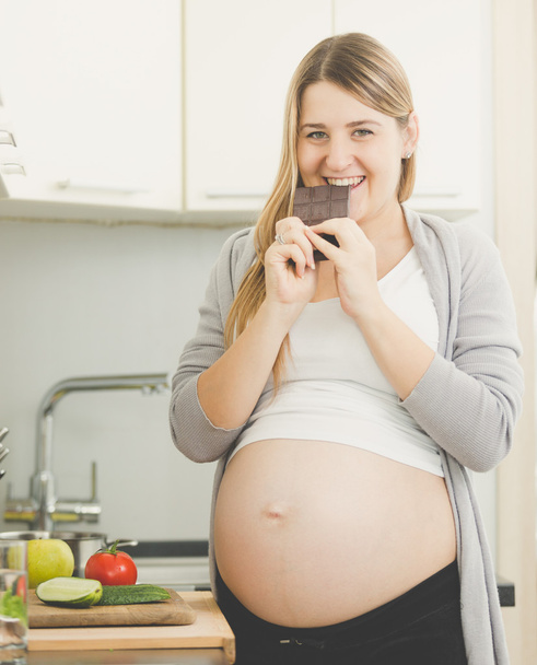 sonriente embarazada comer chocolate
 - Foto, imagen